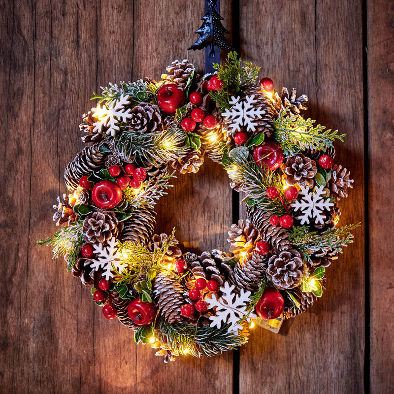 Rustikaler beleuchteter Weihnachtskranz in traditionellen Farben