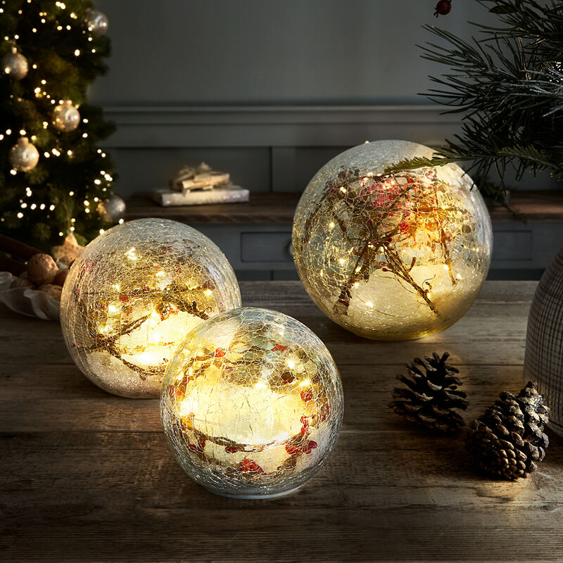 Leuchtkugel inszeniert winterlichen Beerenschmuck