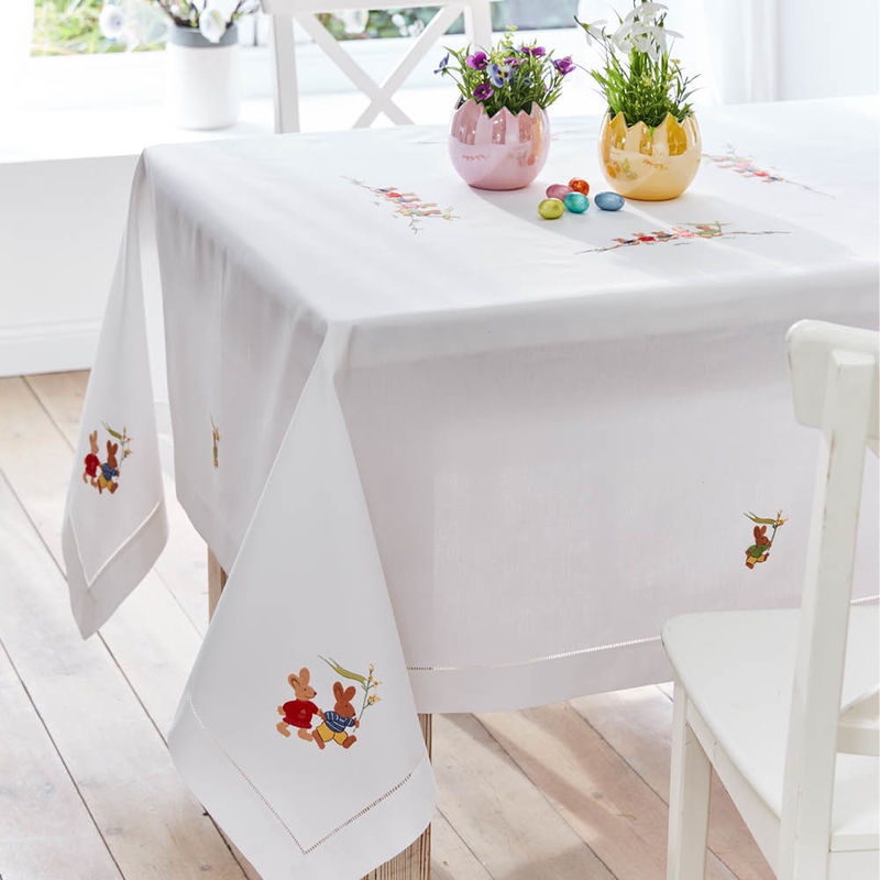 Handstickereien mit niedlichen Hasenmotiven zieren feine Hohlsaum-Tischdecke